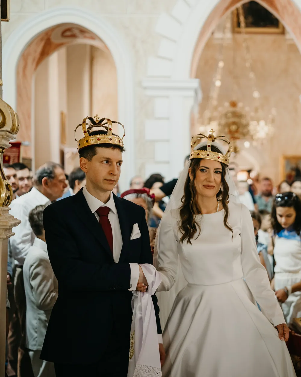 Milica and Nikola wearing wedding crowns during their Orthodox wedding service